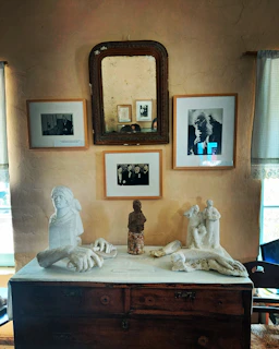 Finished wooden sculptures displayed on rustic tables, bathed in golden afternoon light.