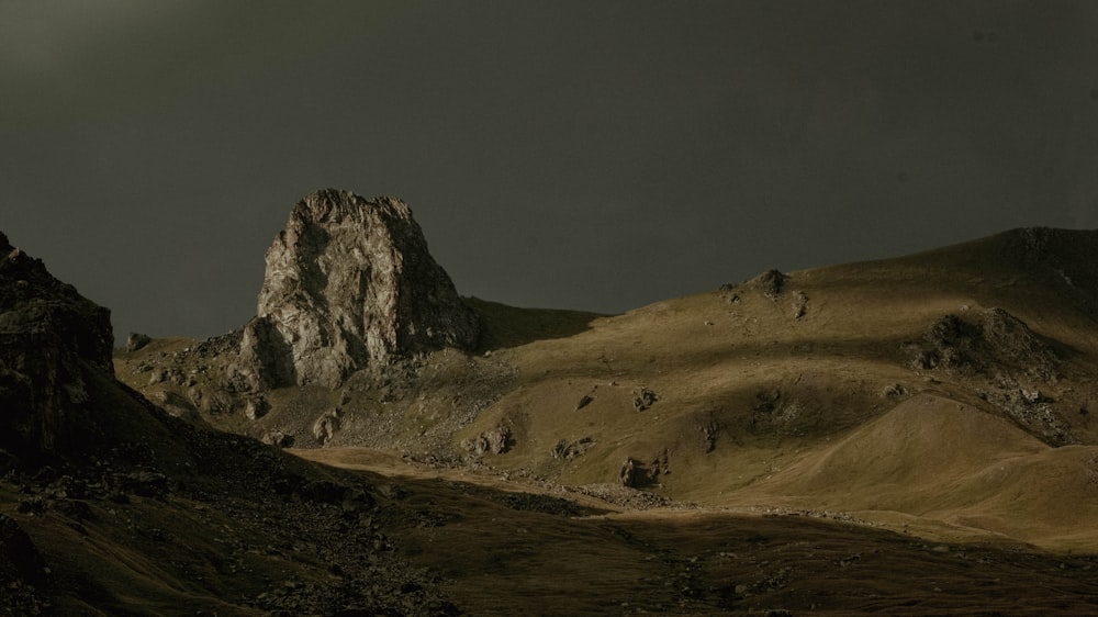 a rocky landscape with a body of water in the foreground