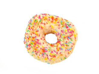 Close-up of a rare slow-rise squishy shaped like a smiling donut with pastel sprinkles on a cream-colored backdrop.