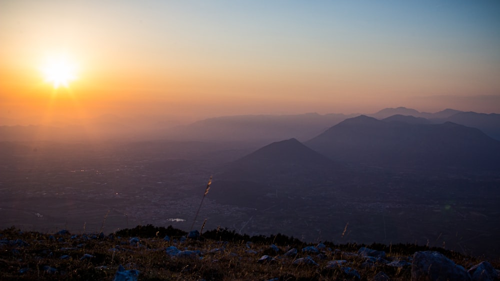 a landscape with mountains and a sunset