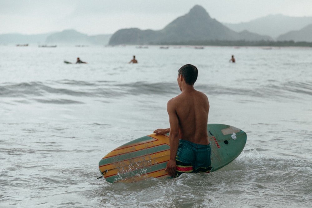 a man holding a surfboard in the ocean