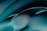 A smooth, abstract design featuring flowing curves and gradients. The image primarily uses shades of teal and black, creating a fluid and dynamic visual effect.