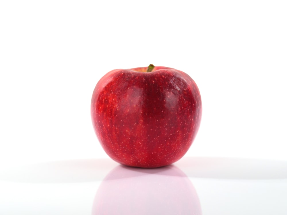 une pomme rouge sur fond blanc