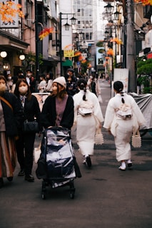 a group of people walking down a street with a person in a garment