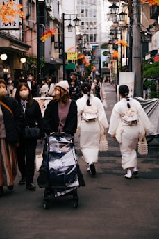 a group of people walking down a street with a person in a garment