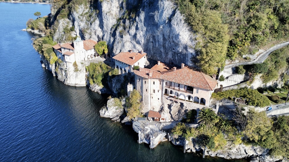a white house on a cliff above water