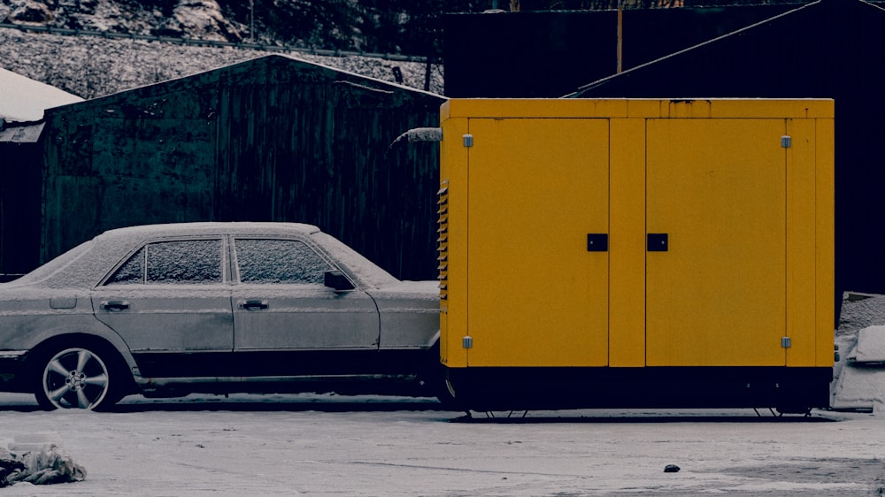a car parked next to a yellow trailer
