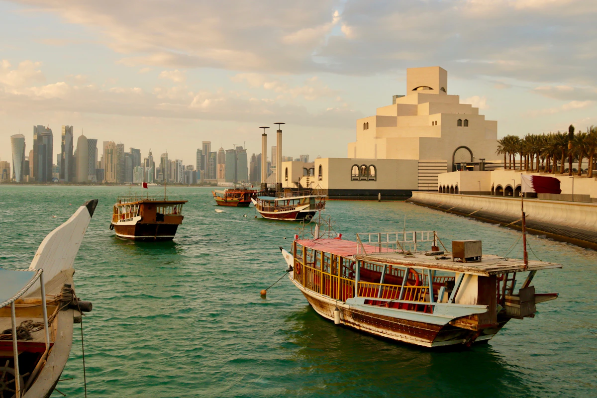 Traditional wooden boats beside the Museum of Islamic Art with Doha's skyline beyond