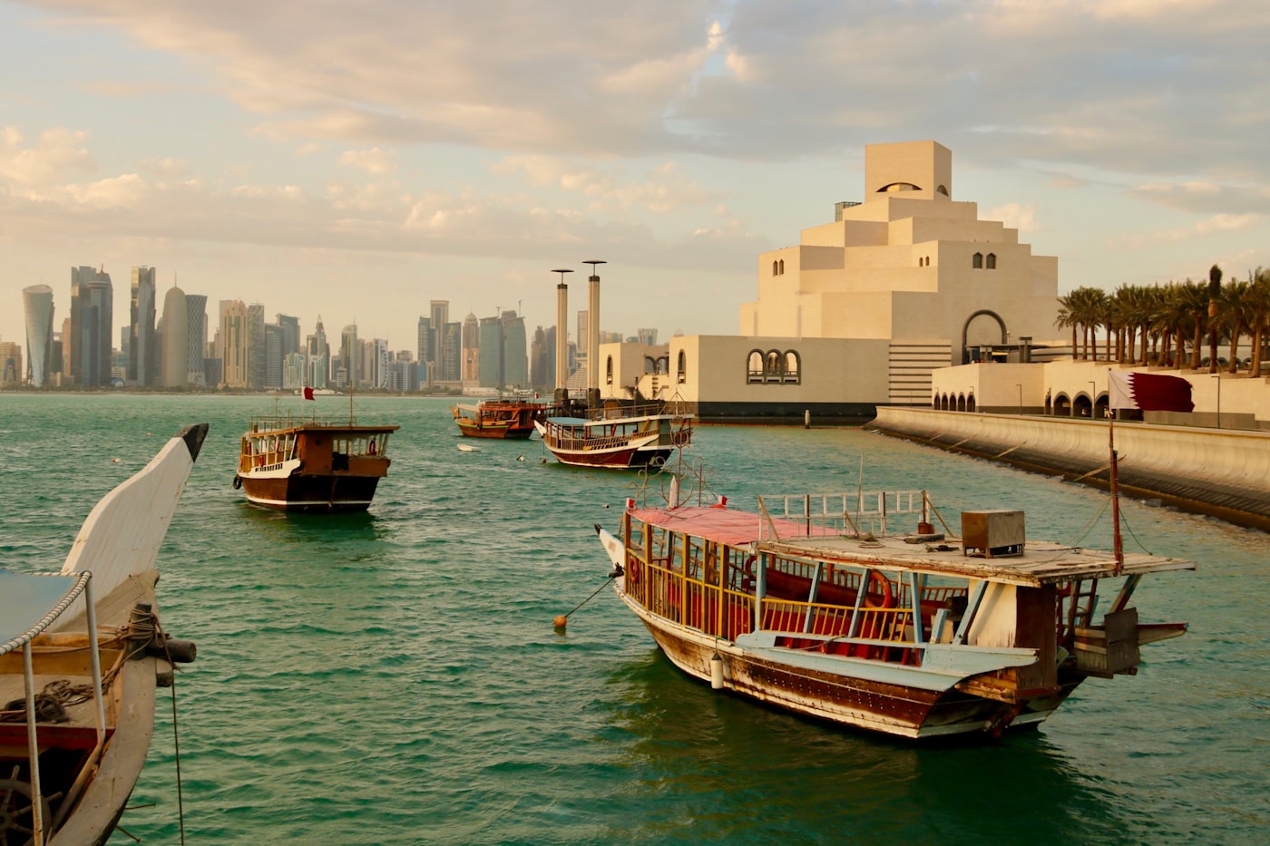 Modern Doha skyline at dusk, reflecting on the water of the Persian Gulf