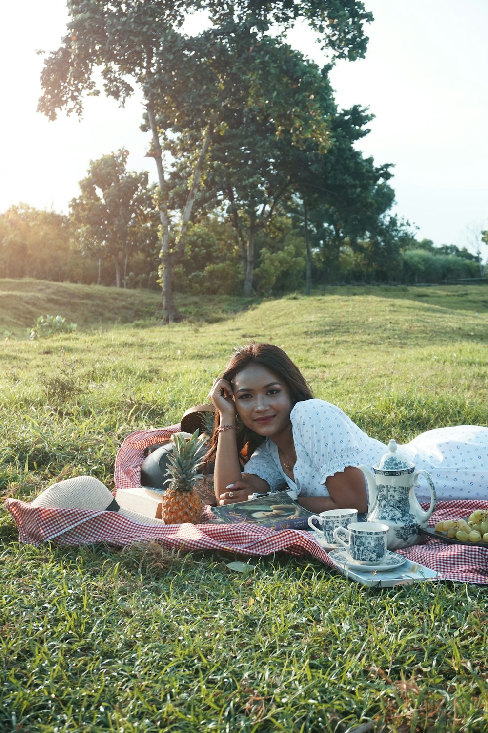 a person sitting on a blanket in a grassy field