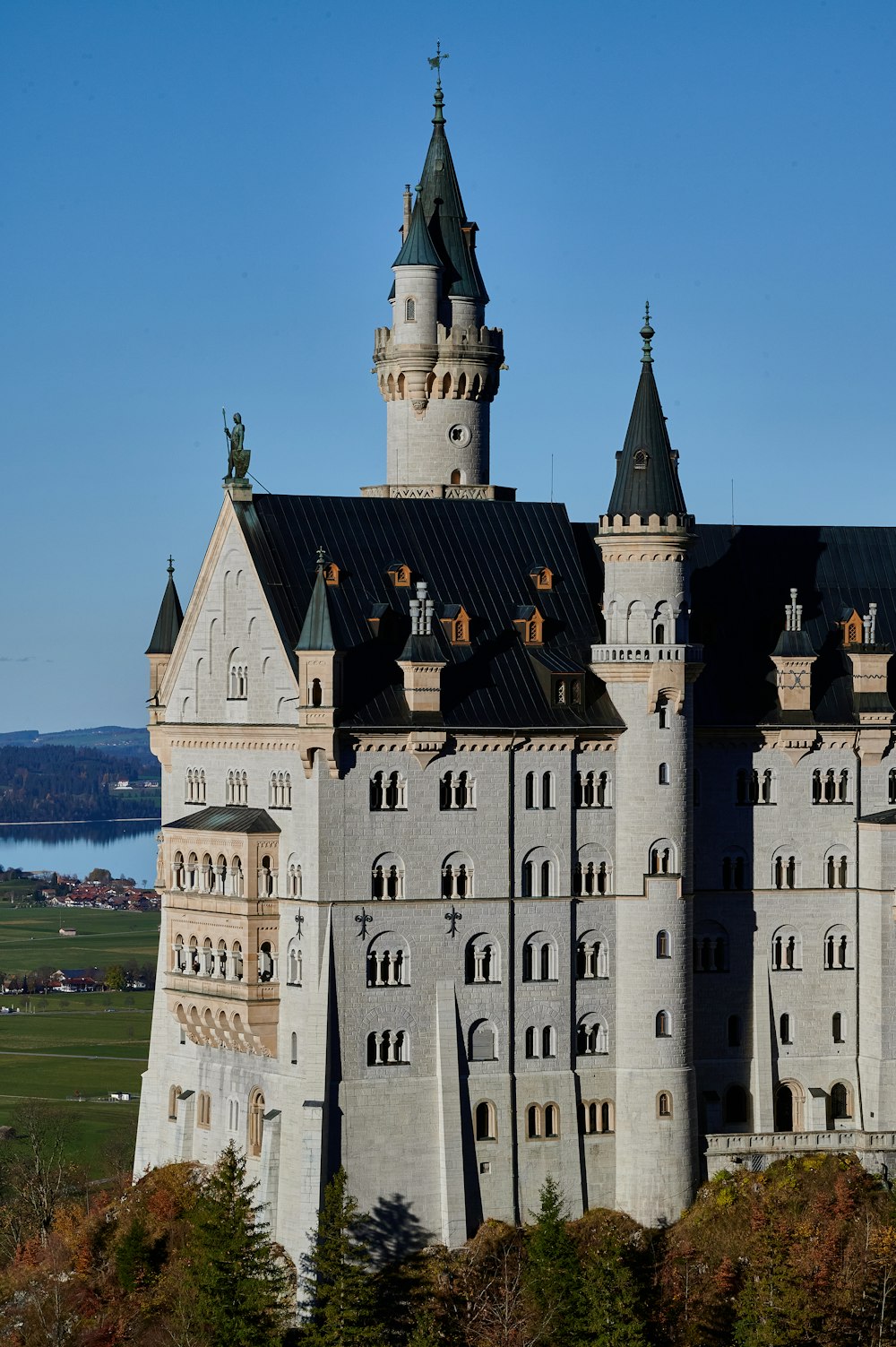 a large castle with a green lawn with Neuschwanstein Castle in the background