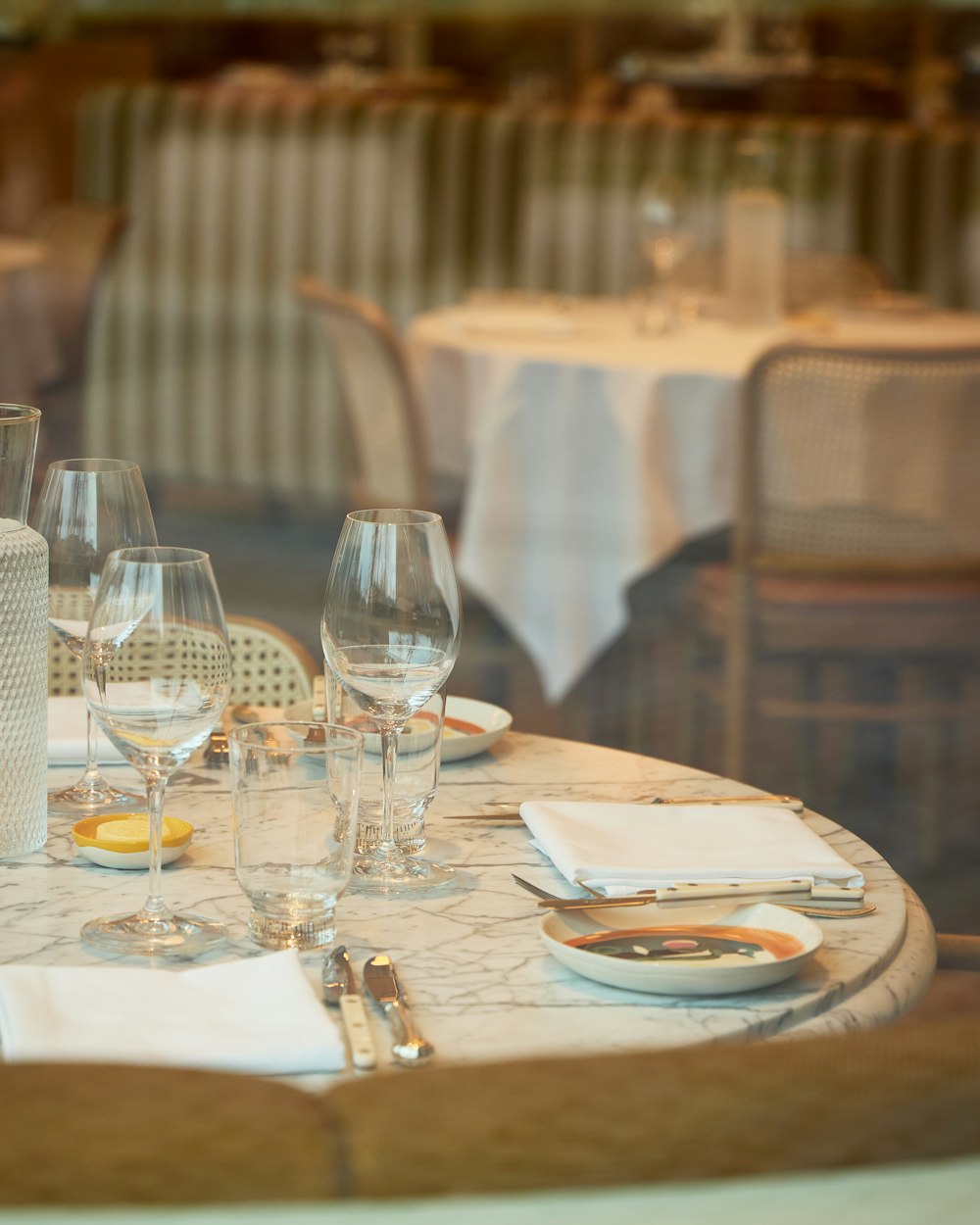 a set of tables with glasses and plates on them