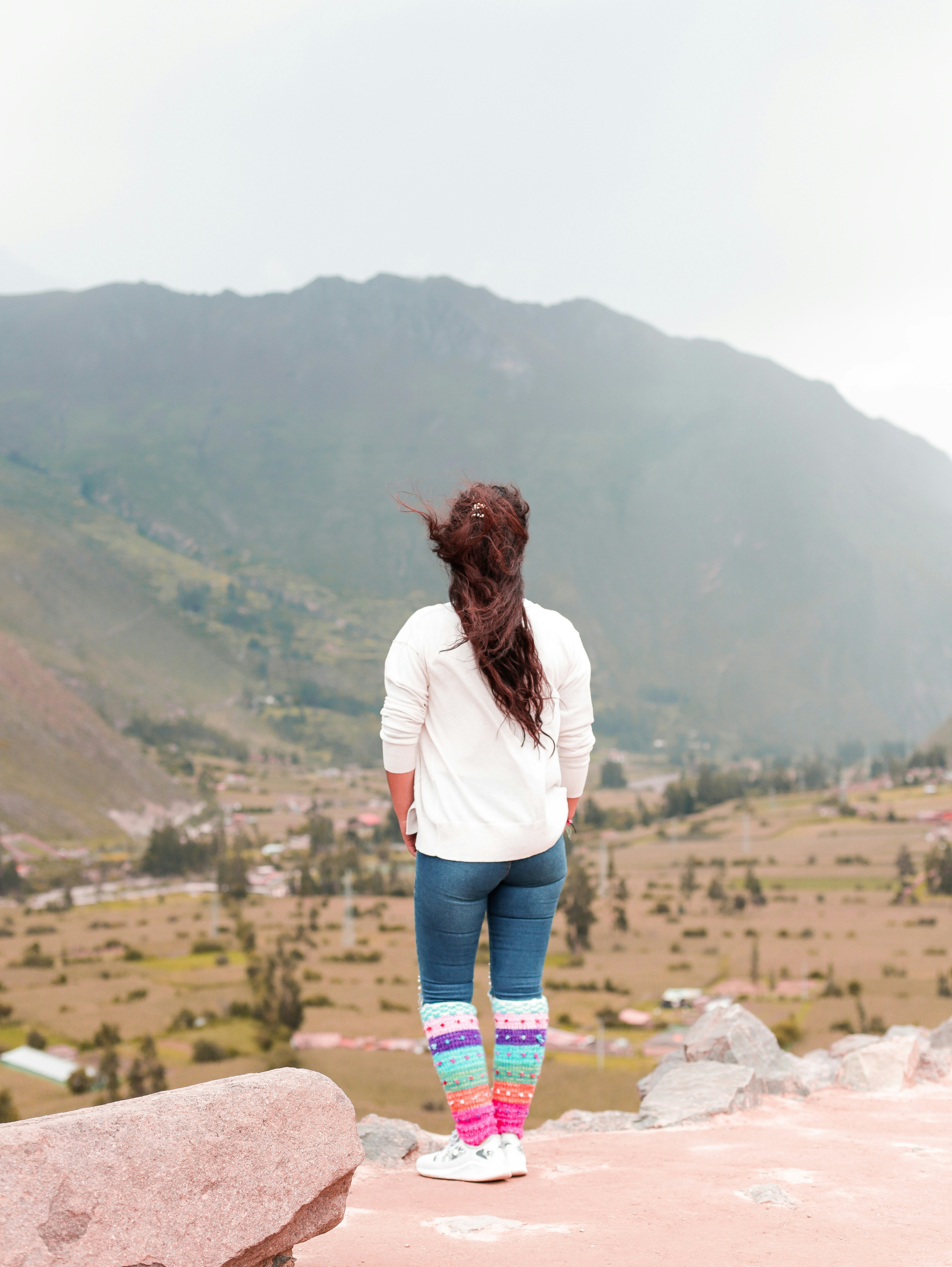 Una persona parada en una repisa con vistas a un valle