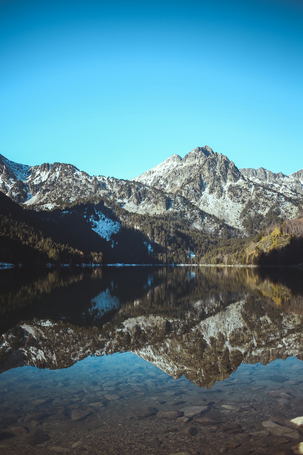 a lake with snowy mountains in the background