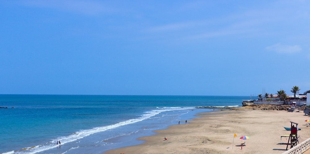 a beach with people and umbrellas