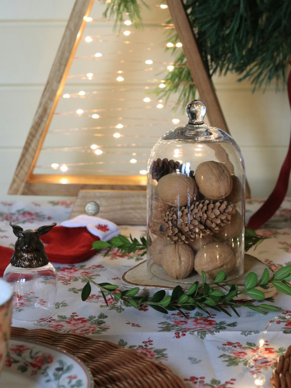 a table with a glass vase and a candle on it