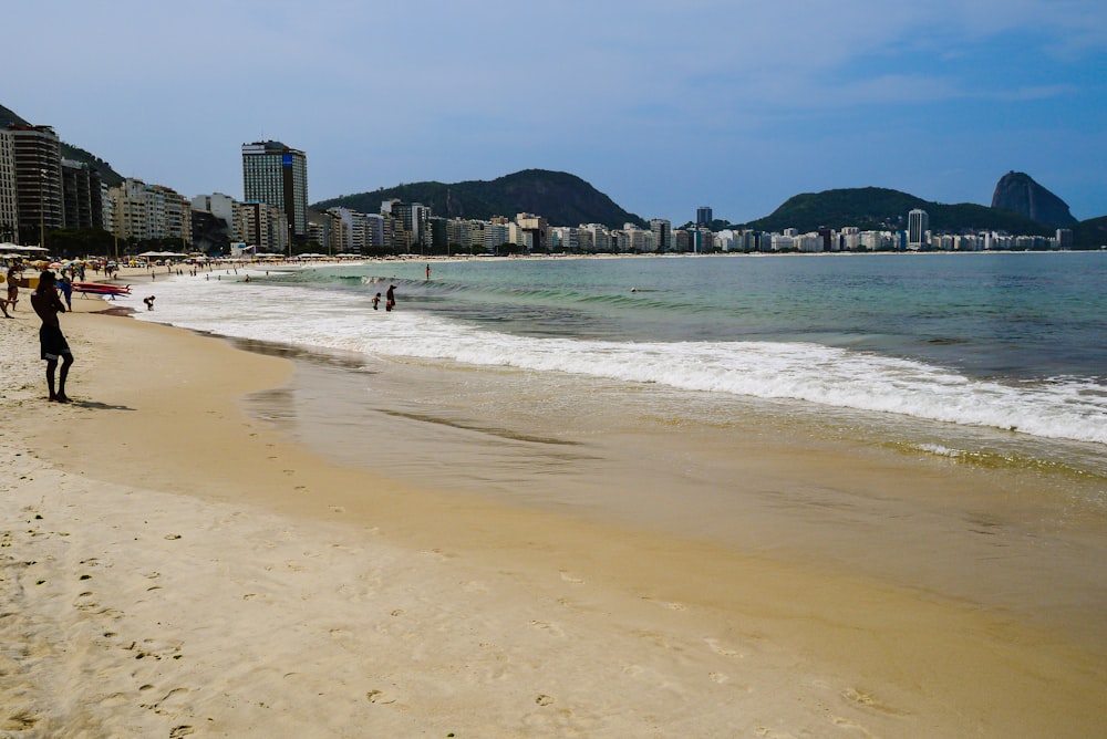 a beach with people and buildings in the background