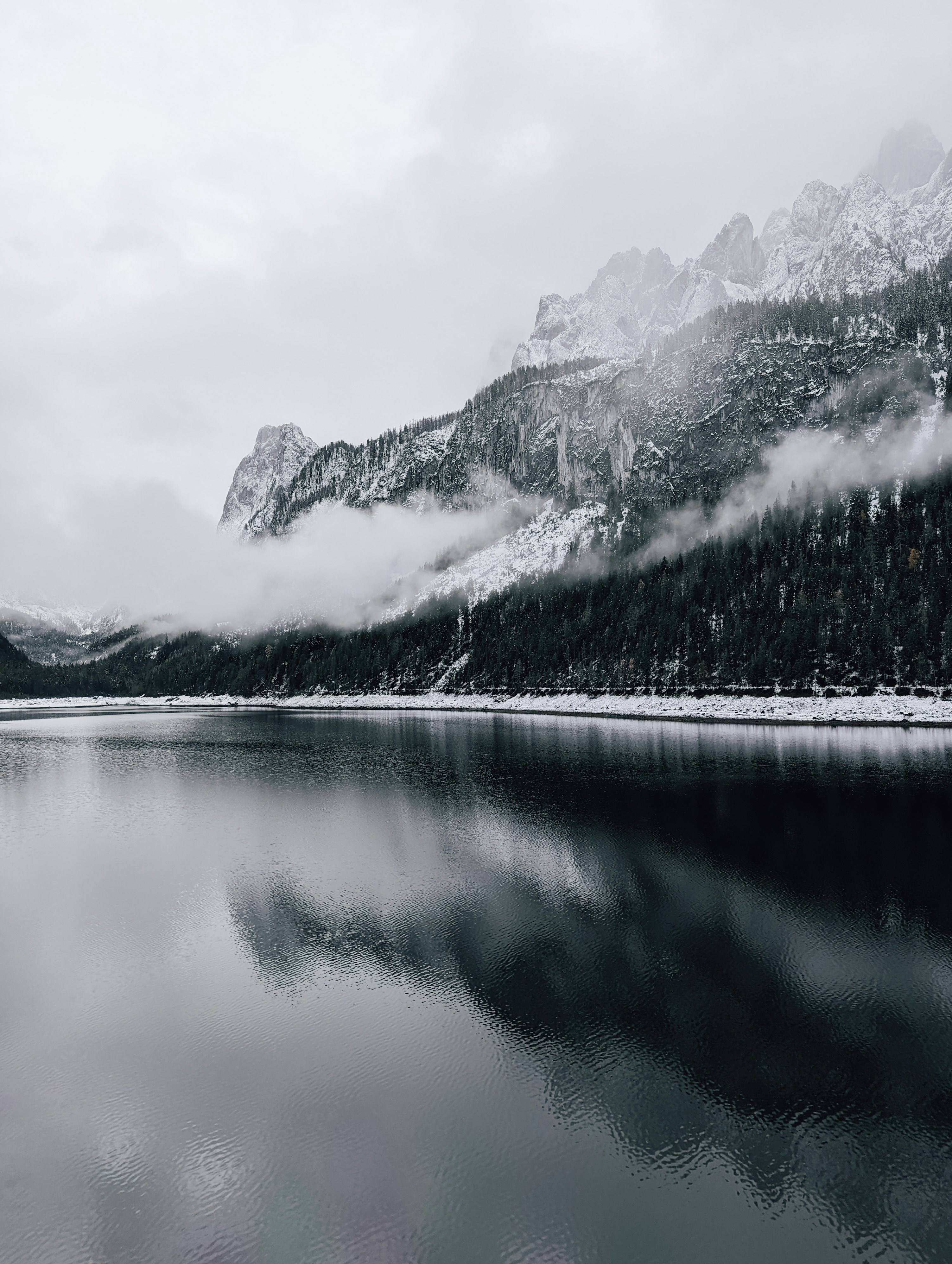 a lake with trees and mountains in the background