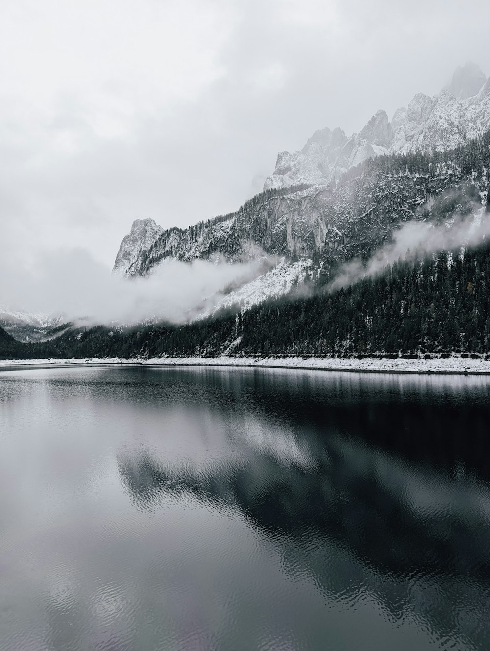 a lake with trees and mountains in the background