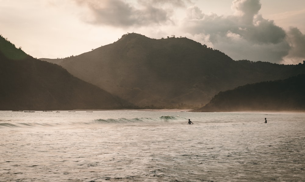 a couple people surfing in the sea