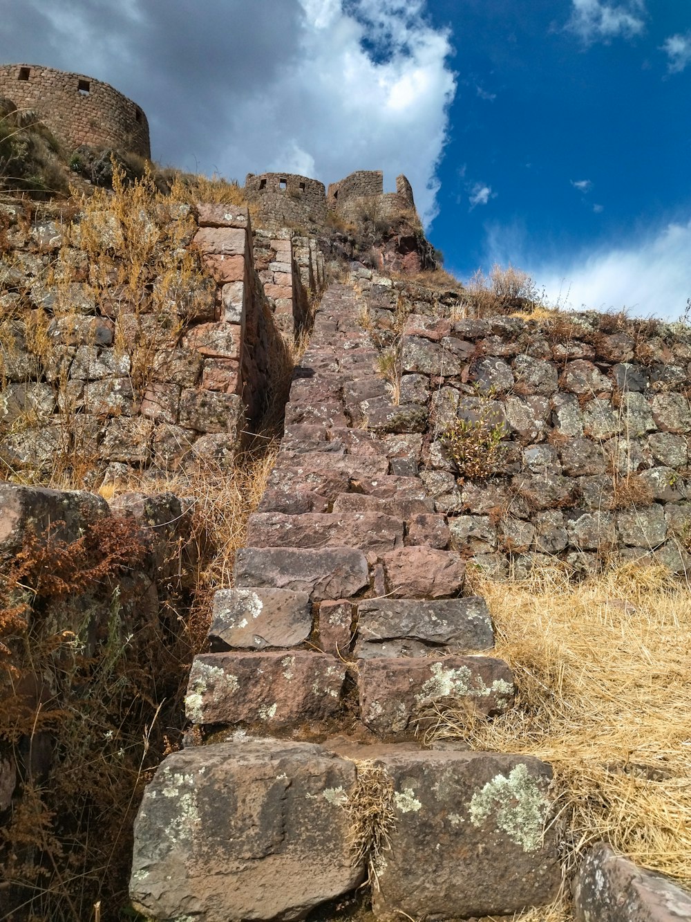 un muro de piedra con un edificio de piedra en la parte superior