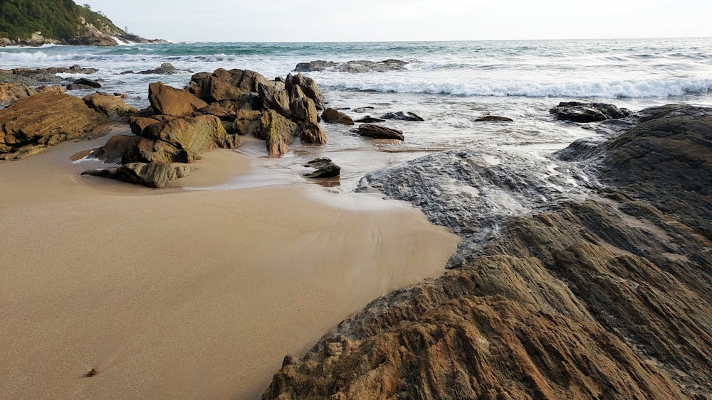 a rocky beach with waves crashing on it