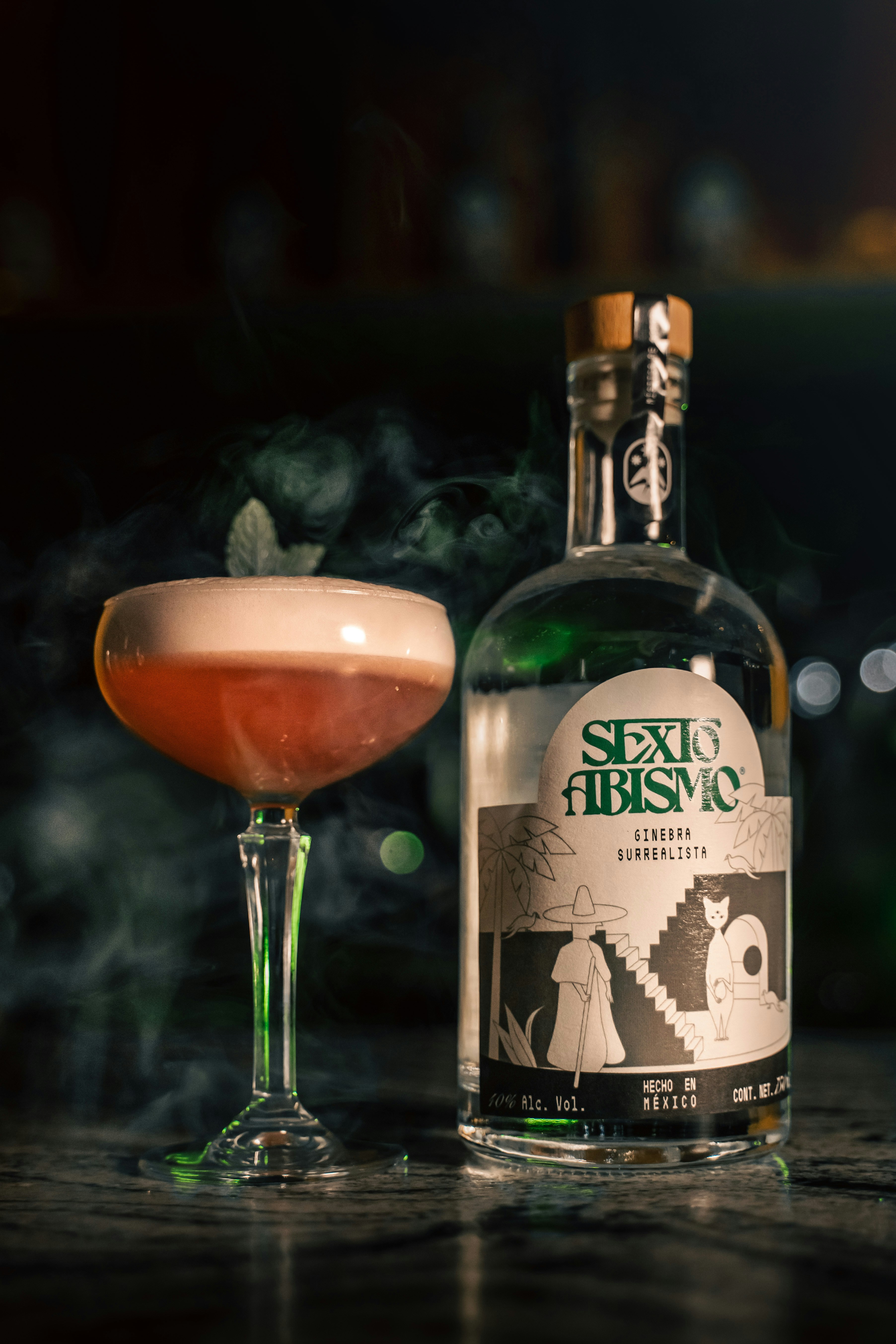 a bottle of alcohol next to a glass of beer