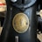 A close-up of an old sewing machine featuring a brass plate with the text 'The Singer Manfg Co' and 'Trade Mark.' The plaque includes an emblem with a threaded needle and decorative elements.
