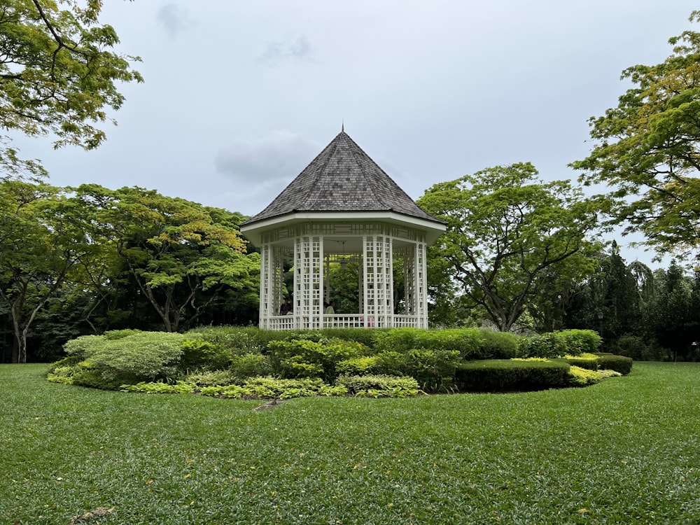 a building with a dome roof surrounded by bushes and trees