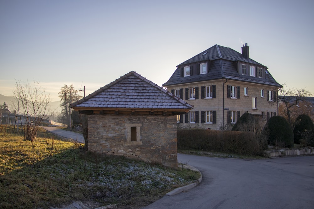 a stone building with a road and grass and trees