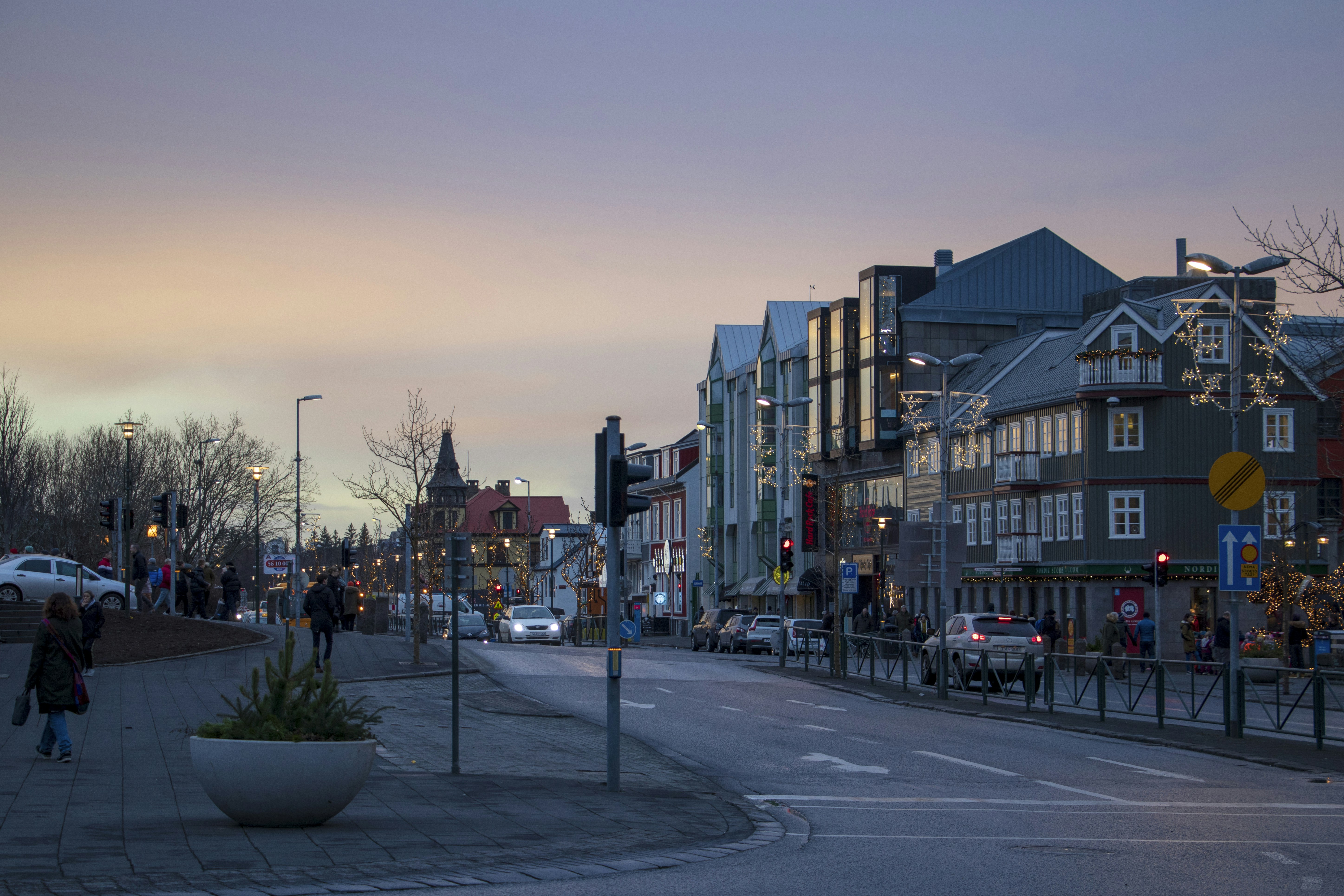 a street with cars and buildings along it, 
