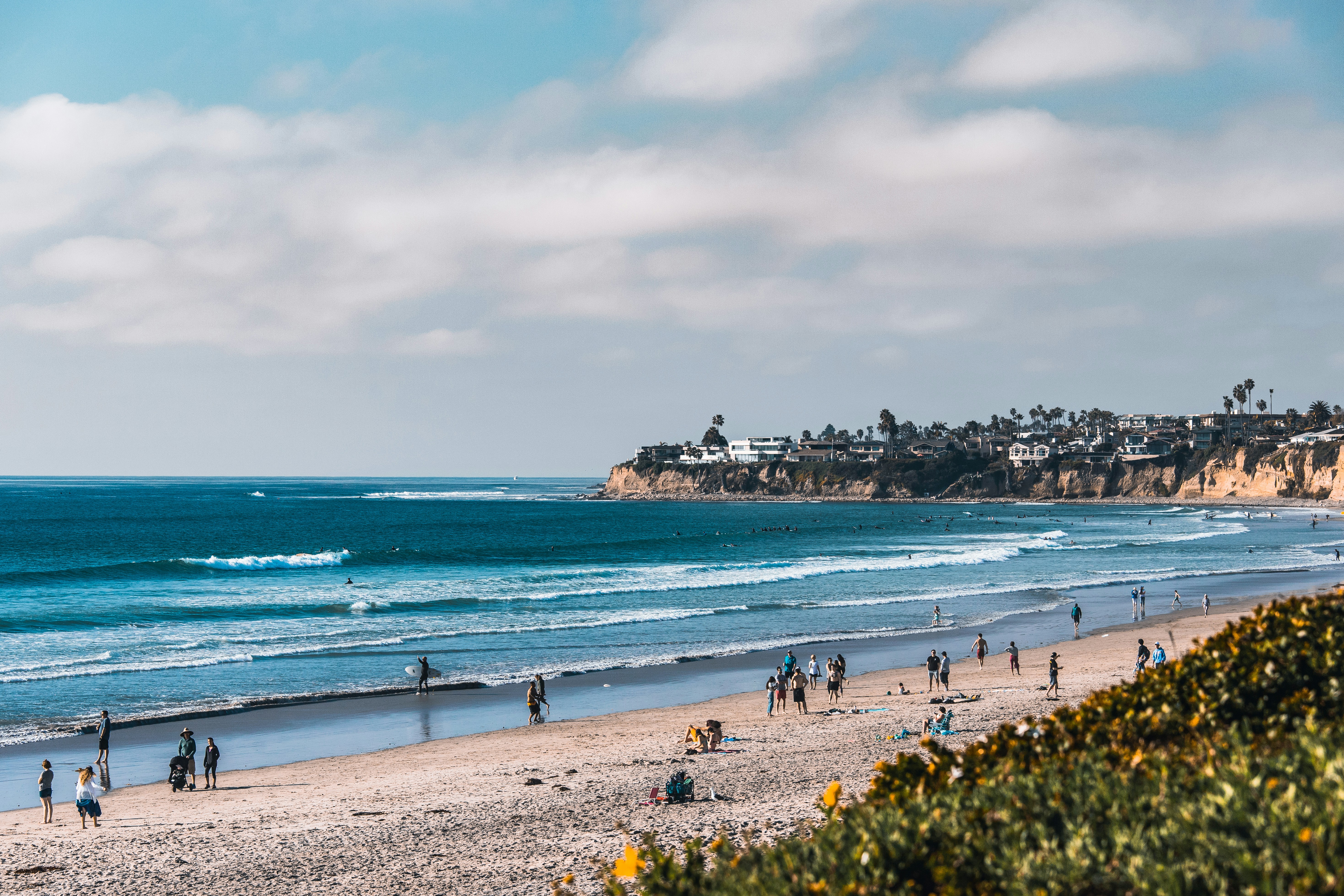a group of people on a beach, Southern California beach on a partly cloudy afternoon.