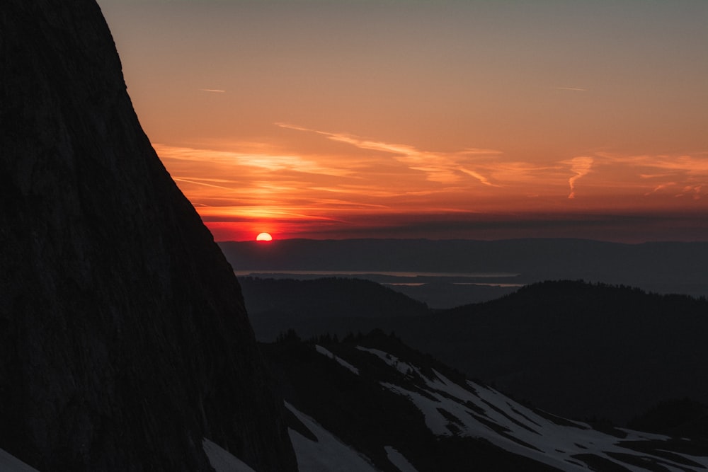 a sunset over a snowy mountain