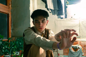 A thoughtful young adult reviewing career options in a bright, colorful workspace.