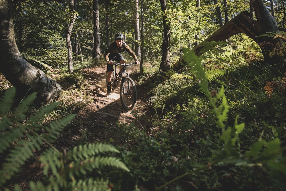 a person riding a bike on a trail in the woods