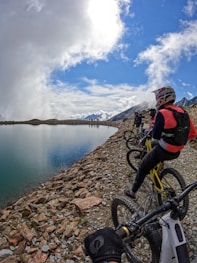 a group of people riding bikes on a rocky shore