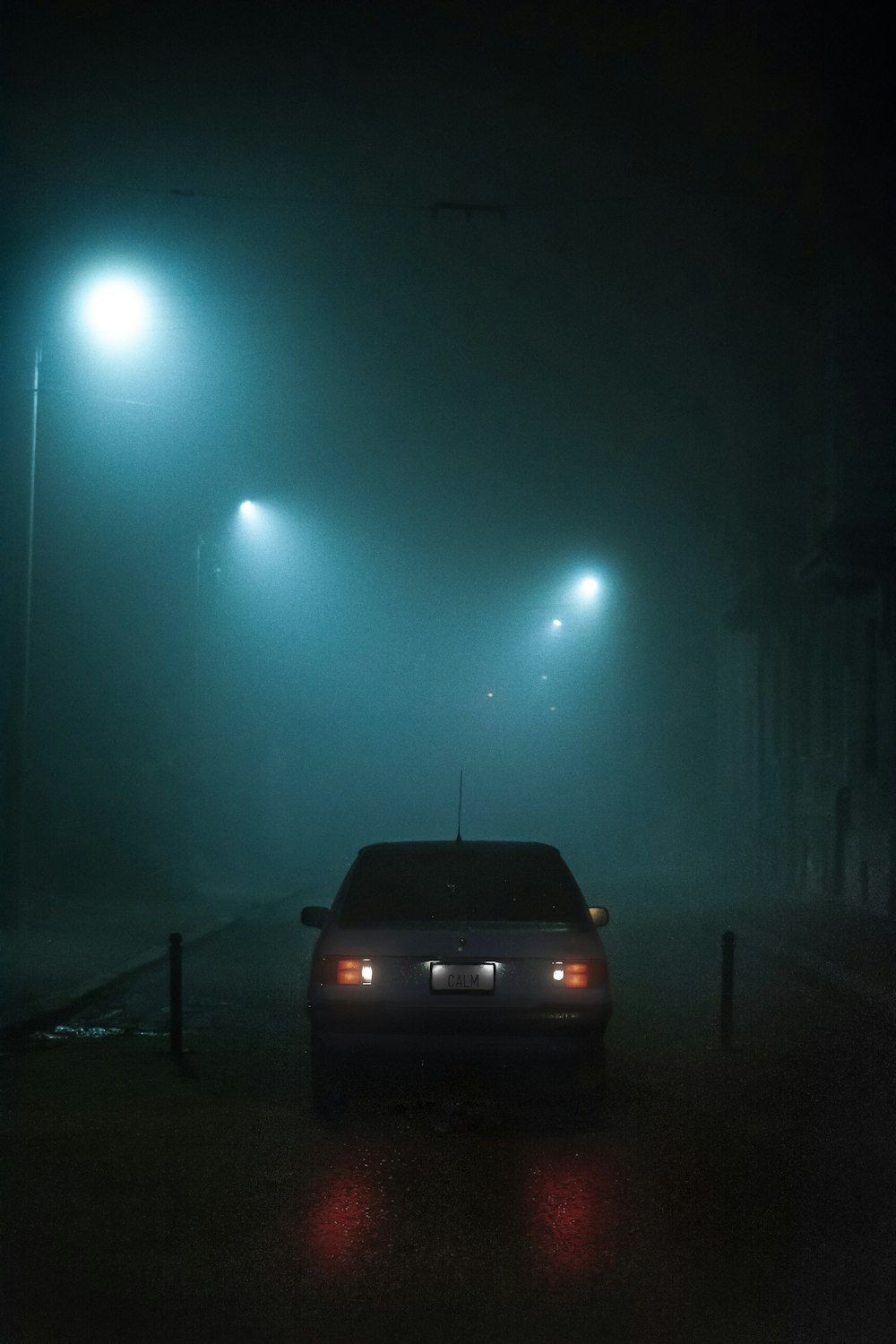 a car parked in a foggy parking lot at night