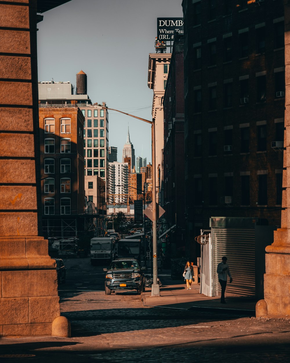 a street with cars and people on it and buildings on the side