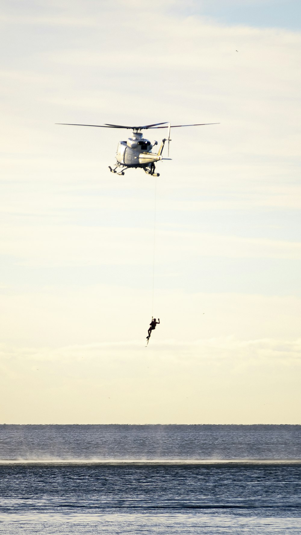 a helicopter and a person in the air with a parachute