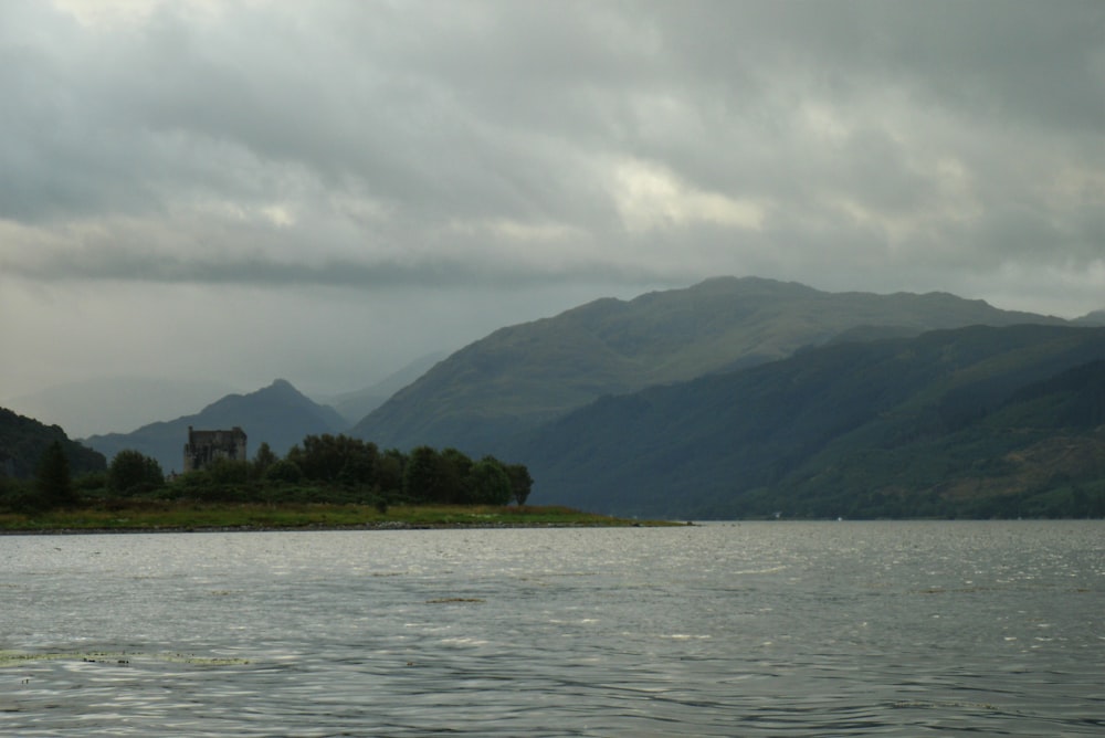 a body of water with trees and mountains in the background