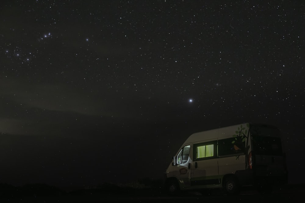 a couple of vans parked in front of a starry sky