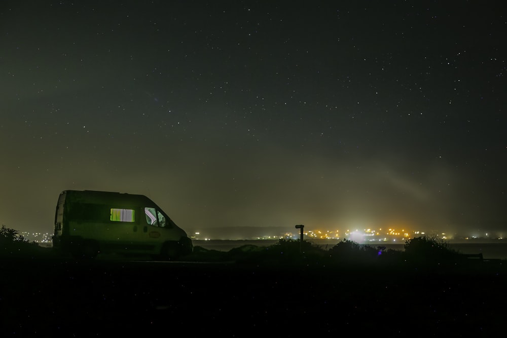 a green car parked on a road at night