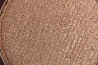 Close-up of a hand applying a shimmering cosmetic product, capturing texture and detail.