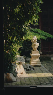 A serene garden corner featuring handmade sculptures among lush greenery.