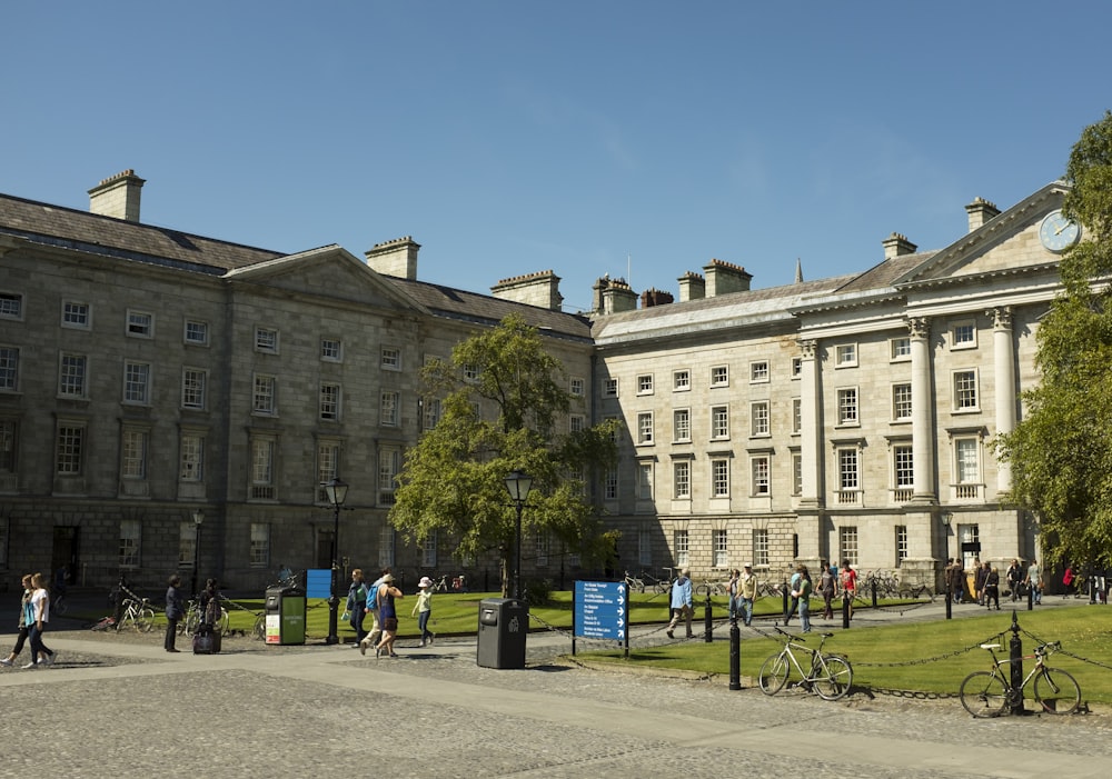 a group of people walking around a large building