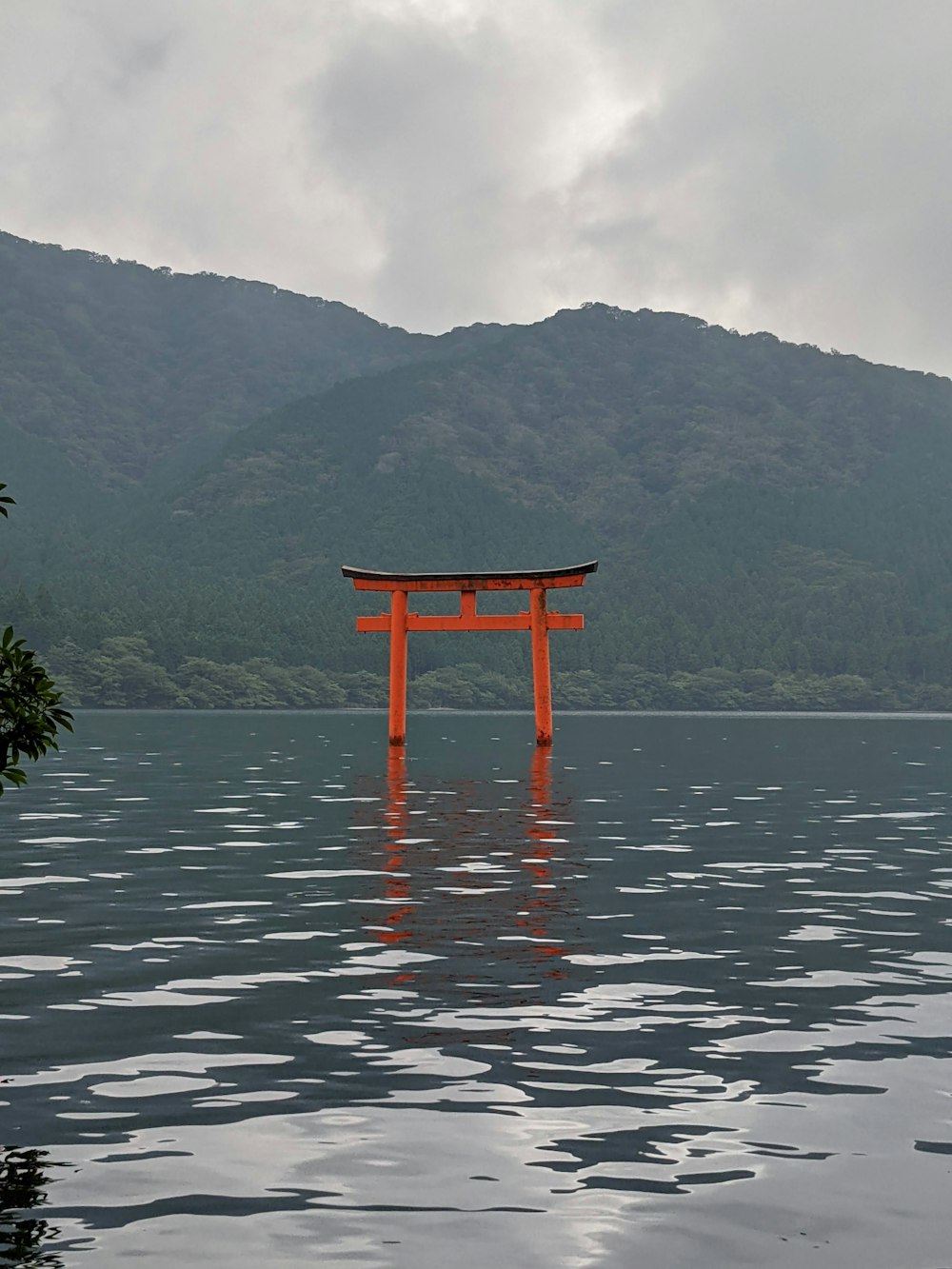 a large wooden structure in a body of water with mountains in the background