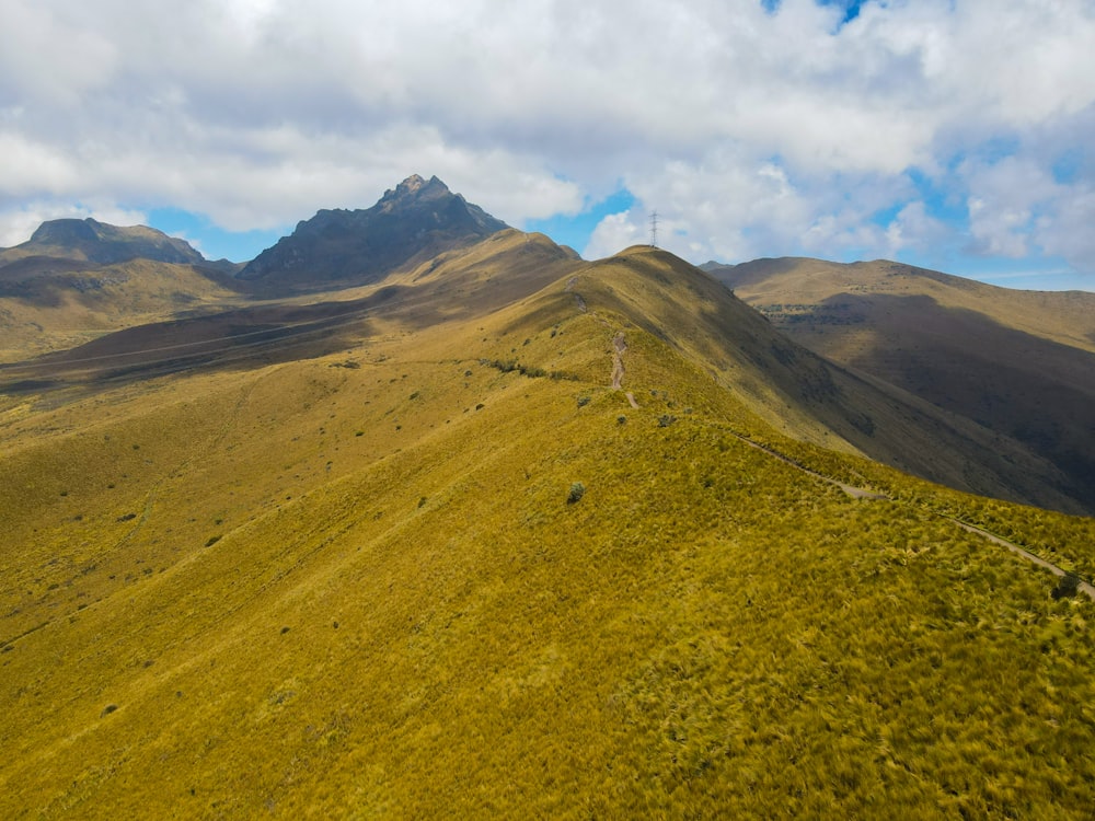 a grassy valley with mountains in the background