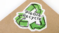 a green and white please recycle symbol