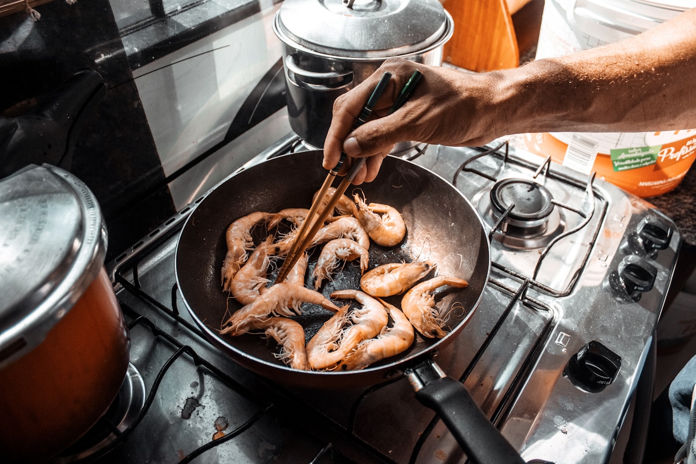 Person kocht in einer warm beleuchteten Küche