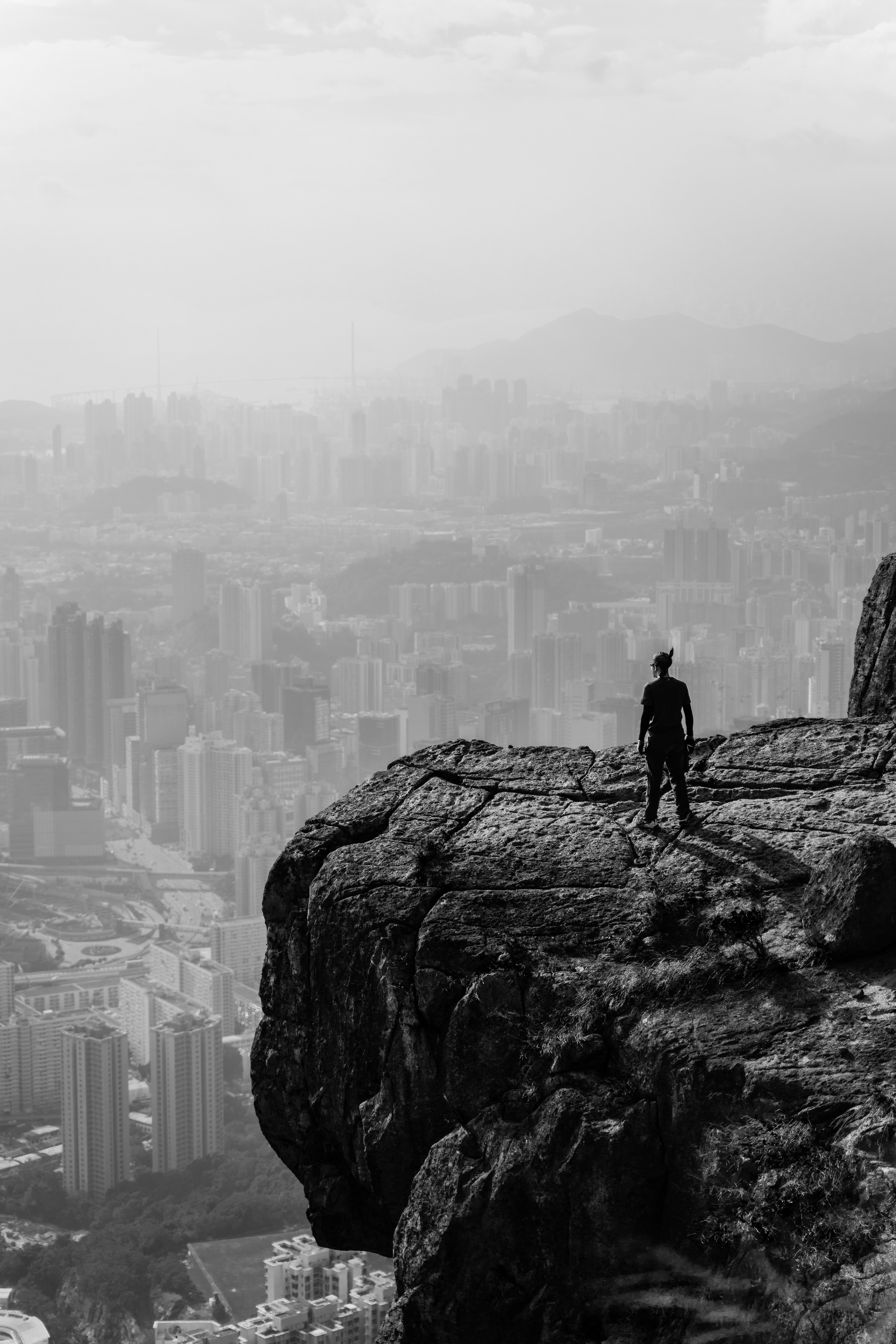 a person standing on a rock overlooking a city
